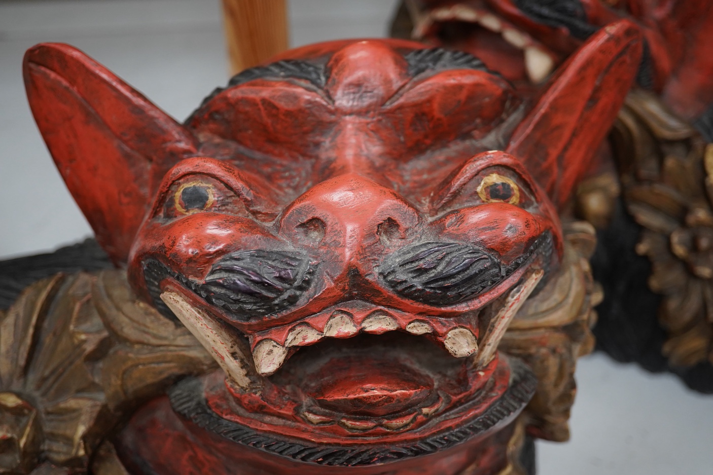 A pair of large Indonesian carved and painted wood lion dogs, 67cm wide.